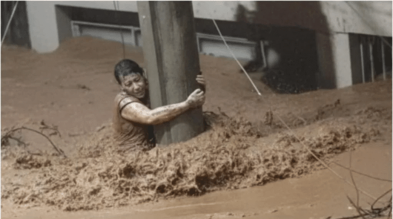 Edna Silva se agarrou a um poste de luz por cerca de três horas ininterruptas durante uma das maiores enchentes já registradas em Ubá, na Zona da Mata. (Reprodução: redes sociais)