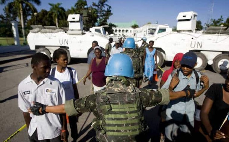Brazilian U.N. peacekeepers maintain order as they distribute food and water in downtown Port au Prince