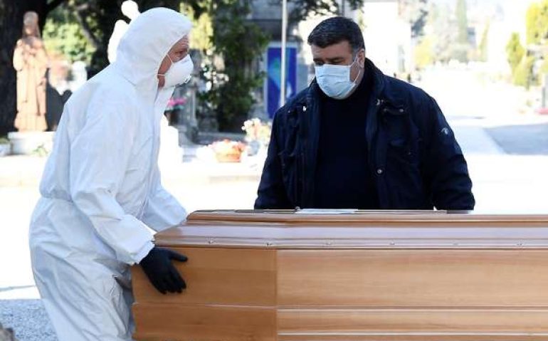 Homens com máscara e roupa de proteção transportam caixão para cemitério em Bergamo 16/03/2020 REUTERS/Flavio Lo Scalzo
