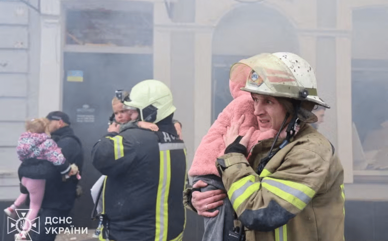 Bombeiros evacuam crianças de jardim de infância atingido por bombardeio russo em Kharkiv, na Ucrânia, em 22 de outubro de 2025. — Foto: Serviço de emergências da Ucrânia/Handout via REUTERS