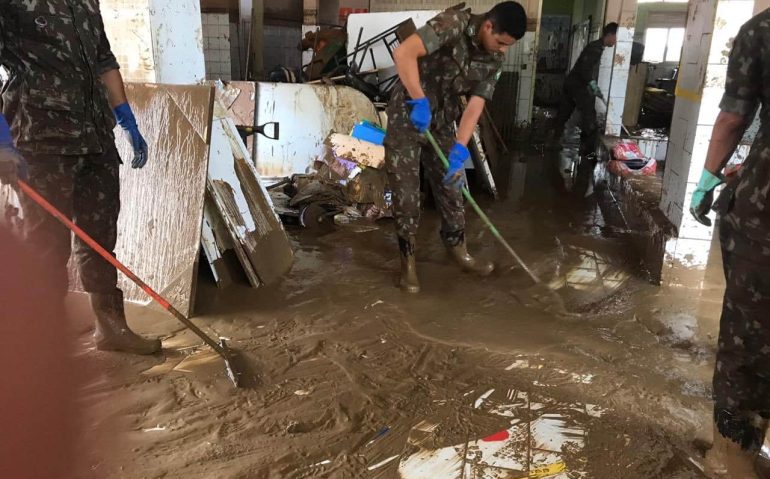 Militares do Exército removem a lama acumulada em um prédio devastado pela enchente no ES