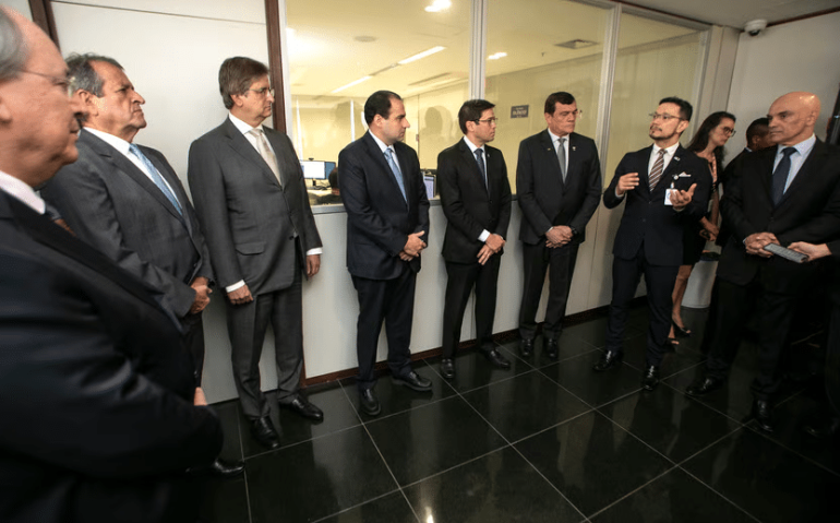 O general, o sexto da esquerda para a direita, ouve o secretário Julio Valente. Foto: Alejandro Zambrana/Secom/TSE