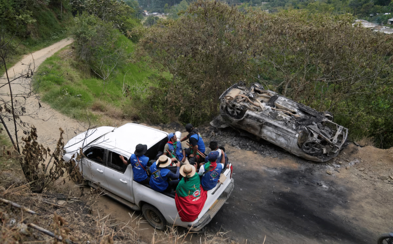 Miembros da Guarda Indígena passaram junto com um carro que sofreu um ataque dos rebeldes do Estado Mayor Central, o EMC, em Toribio, Colômbia, em 19 de março de 2024. Foto: Fernando Vergara/ AP