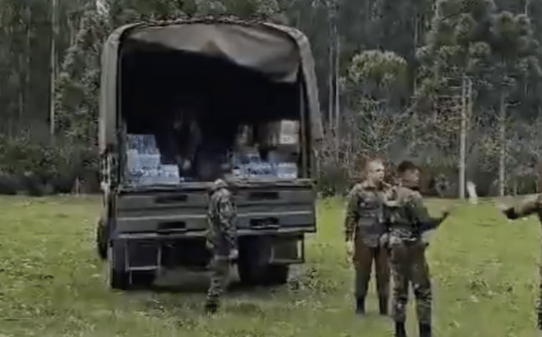No vídeo compartilhado nas redes sociais, militares aparecem descarregando suprimentos uma garrafa de cada vez...