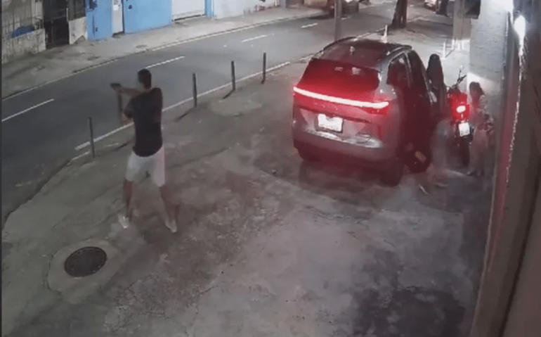 Na imagem é possível ver um dos criminosos baleados no chão ao lado do carro - Foto: Reprodução