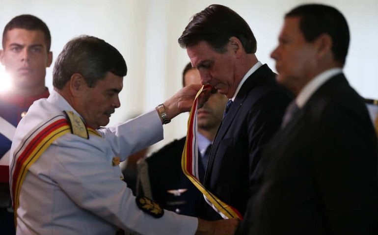 O presidente do STM, Marcus Vinicius Oliveira dos Santos, coloca faixa em Jair Bolsonaro em
cerimônia de comemoração ao aniversário da Justiça Militar da União - Pedro Ladeira - 28.mar.19/Folhapress