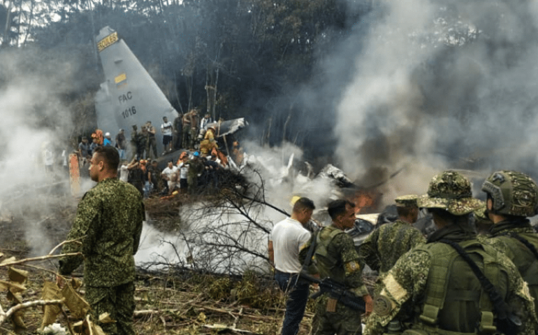 Soldados e equipes de resgate perto de um Hércules da Força Aérea emitindo fumaça densa após a aeronave ter caído durante a decolagem em Puerto Leguizamo, Colômbia. (Daniel Ortiz/AFP)