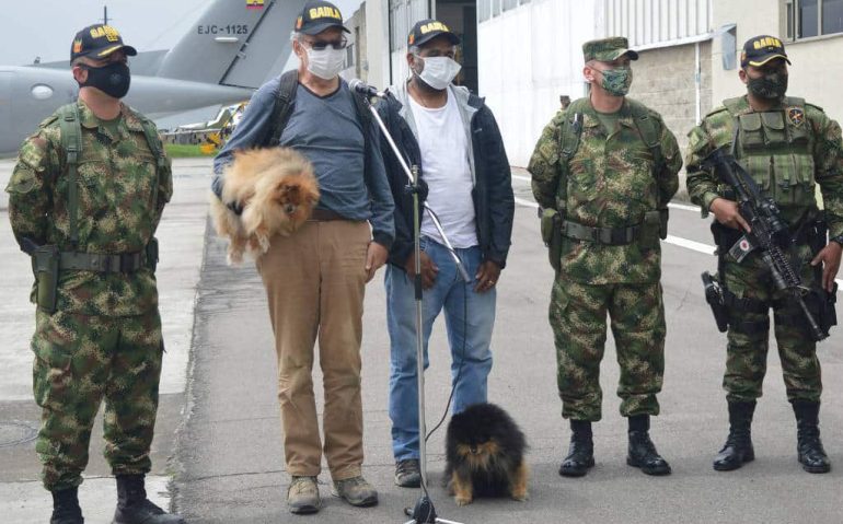 O suíço Daniel Max Guggenheim, segurando o cachorro, e o brasileiro José Ivan Albuquerque durante entrevista coletiva na base militar de Bogotá - Exército da Colômbia