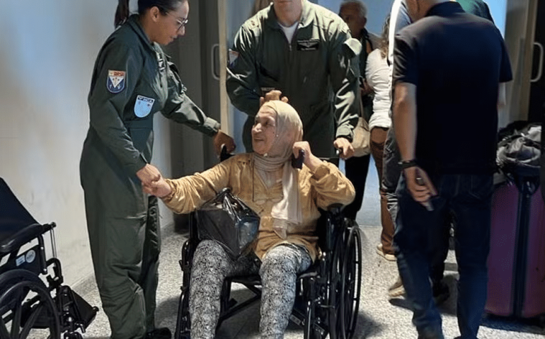 Brasileira é ajudada por militares da FAB a embarcar no terceiro voo de resgate do Líbano — Foto: Divulgação/ FAB
