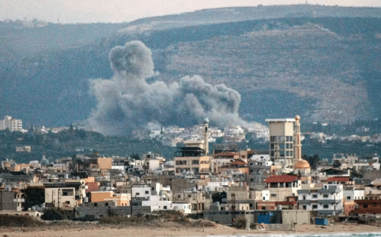 Visão geral da cidade de Tiro, no sul do Líbano, mostra uma nuvem de fumaça surgindo após um ataque aéreo israelense na vila de Qlayleh em 30 de setembro de 2024 — Foto: Kawnat HAJU / AFP