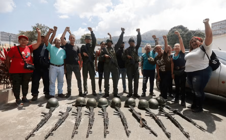 Membros dos Conselhos Comunitário e Civil ao lado de rifles durante um treinamento militar sobre armamento, no Forte Tiuna, em Caracas — Foto: Pedro Mattey/AFP