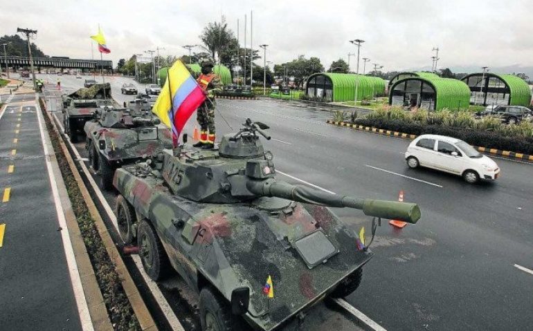 Soldado coloca bandeira da Colômbia em blindado em Bogotá (Daniel Munõz/AFP)