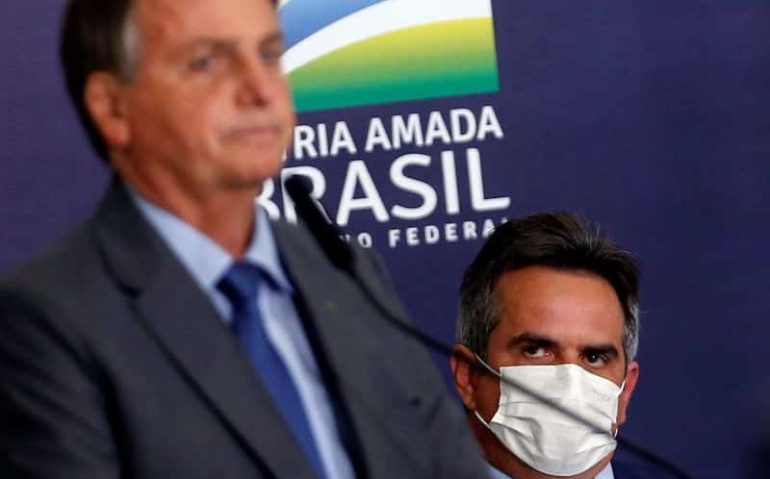 © Reuters. Presidente Jair Bolsonaro é observado por Ciro Nogueira durante cerimônia no Palácio do Planalto 27/07/2021 REUTERS/Adriano Machado