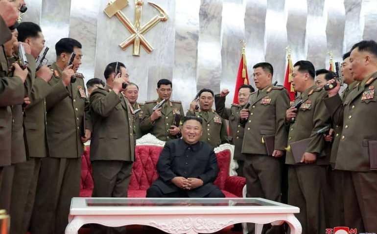 Kim Jong-un, líder da Coreia do Norte, com militares posando com pistolas comemorativas no aniversário dos 67 anos da assinatura do armistício que colocou fim aos combates na Guerra da Coreia Foto: KCNA / AFP
